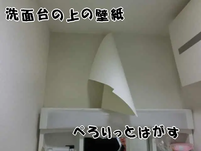 洗面台の上にある壁紙を剥がしている様子